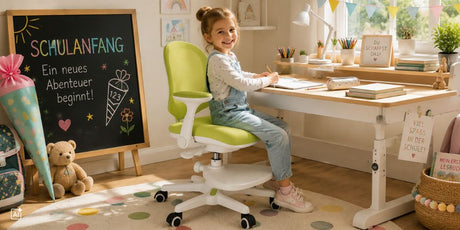 Ein Schulkind sitzt auf einem Kinderschreibtischstuhl am Tisch und malt etwas. Sie lächelt. Hinter ihr steht ein Teddy, ihr Schulranzen, eine Schultüre und eine kleine Tafel.